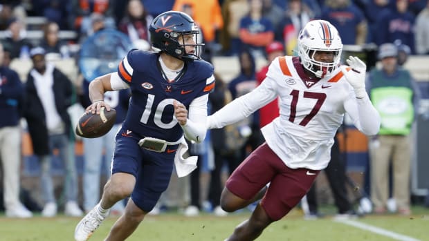 Virginia Cavaliers quarterback Anthony Colandrea (10) scrambles from Virginia Tech Hokies defensive lineman Cole Nelson (17) during the first quarter at Scott Stadium.